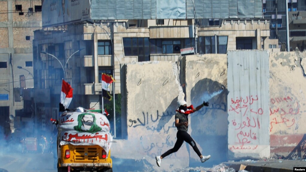 A demonstrator throws away a tear gas canister during an anti-government protests in Baghdad, Iraq November 1, 2019.