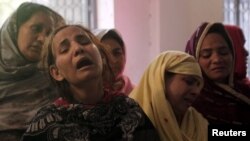 Family members mourn the death of a relative, who was killed in a blast that happened outside a public park on Sunday, in Lahore, Pakistan, on March 28. 