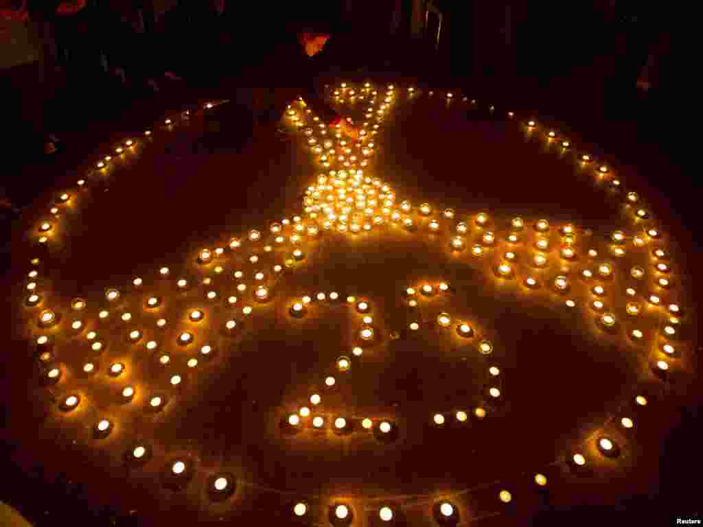 A participant of the international conference "25 years after Chernobyl" lights a candle in Minsk on April 18. Belarus, Ukraine, and Russia will mark the 25th anniversary of the nuclear reactor explosion in Chornobyl, site of the world's worst civil nuclear accident, on April 26.Photo by Vasily Fedosenko for Reuters