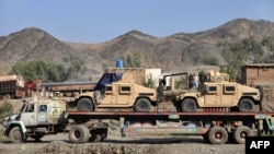Pakistan -- Drivers stand beside a truck carring Humvee for NATO forces in Afghanistan parked at Torkham border crossing, 28Nov2011
