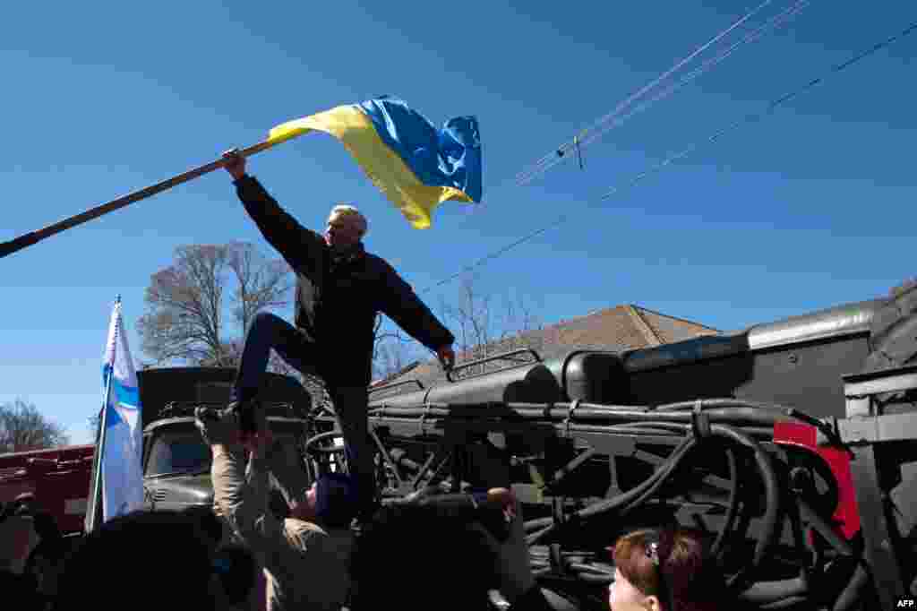Проросійський протестувальник скидає український прапор під час штурму української військово-повітряної бази в Новофедорівці, 22 березня 2014 року