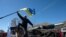 A pro-Russian protester takes down a Ukrainian flag as a group of some 200 protesters storm a Ukrainian air base in the small city of Novofedorivka in western Crimea on March 22.