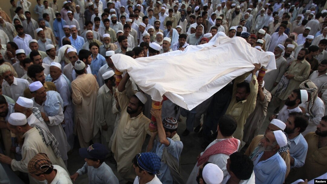 Residents carry the draped body of a suicide bomb victim to his grave in Pabbi, east of Peshawar, in July.
