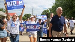 U.S. -- Democratic 2020 U.S. presidential candidate and former Vice President Joe Biden walks with supporters at the Independence Day parade in Independence, Iowa, July 4, 2019.