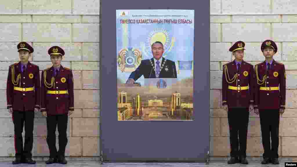 Military academy students stand next to a poster of President Nazarbaev at the opening of an exhibition to mark the inaugural Day of the First President in the Central National Museum in Almaty.