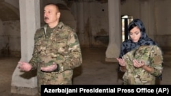 Azerbaijani President Ilham Aliyev and his wife, Vice President Mehriban Aliyeva, pray inside a mosque recaptured from ethnic Armenian forces during the 2020 conflict in Nagorno-Karabakh.