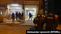 Police officers consult with each other outside a metical center in Podgorica, Montenegro.