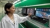 Kyrgyzstan -- A Kyrgyz specialist with a mockup of the domestically produced satellite. 