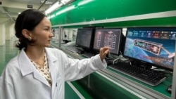 Kyrgyzstan -- A Kyrgyz specialist with a mockup of the domestically produced satellite. 