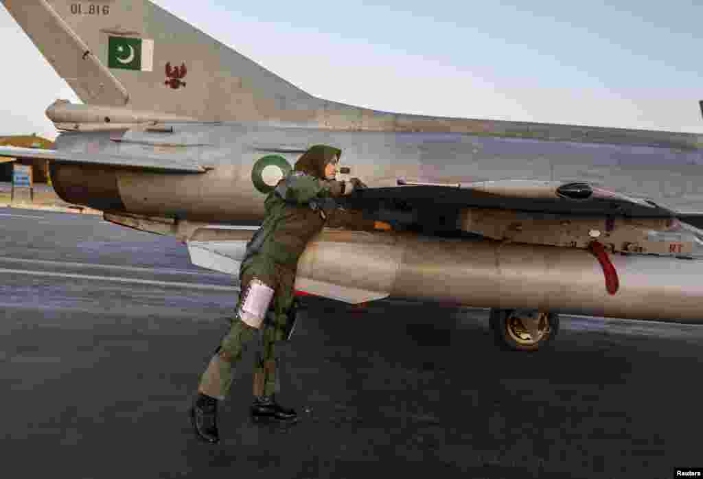 Ayesha Farooq performs a pre-flight check on a Chinese-made F-7PG fighter jet at Mushaf base in Sargodha