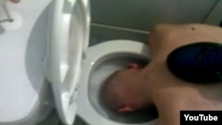 The first video shows a purported inmate at the facility naked and being forced to dunk his head in toilets, which his tormentors proceed to flush.