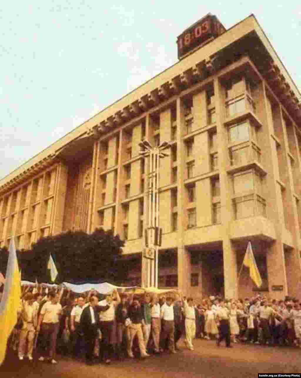 АРХІВНЕ ФОТО. Люди несуть прапор до Київради повз Будинок профспілок від Софії Київської, де він був освячений майбутнім патріархом, а тоді архімандритом УАПЦ Володимиром (Романюком) за участі священників УАПЦ і УГКЦ. Київ, 24 липня 1990 року&nbsp;