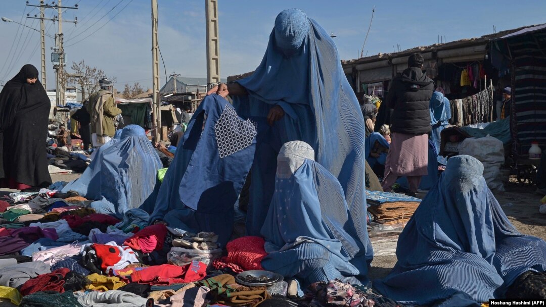 Burqa-clad women sell clothes along a road in Afghanistan (file photo)