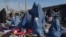 Burqa-clad women sell clothes along a road in Afghanistan (file photo)
