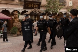 Қашқар көшесін күзетіп жүрген полиция қызметкерлері. Қытайдың Шыңжаң аймағы, 4 мамыр 2021 жыл.