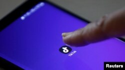 Значок мобильного приложения социальной сети TikTok на экране смартфона.