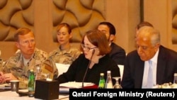 U.S. special envoy Zalmay Khalilzad (right) attends peace talks in Doha on March 12.