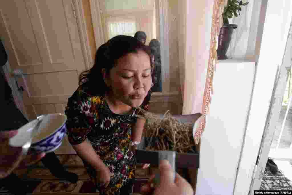Женщина пытается поджечь траву, которая, по поверью, защищает от сглаза. Этот огонь жених должен «погасить» водой.