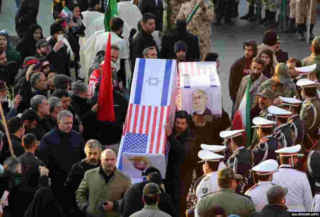 Mourners carry mock coffins with images of U.S. President Donald Trump and Israeli Prime Minister Benjamin Netanyahu.