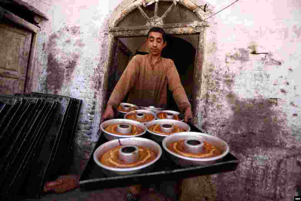 An Afghan boy prepares traditional sweets ahead of the Muslim festival of Eid Al-Adha in Herat. (epa/Jalil Rfezayee)