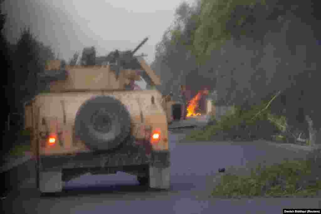 A Humvee hit by a rocket-propelled grenade (RPG) burns during an early morning mission by Afghan special forces on July 13. The elite troops were attempting to rescue police commander Ahmad Shah, who was besieged by Taliban militants on the outskirts of the southern city of Kandahar.