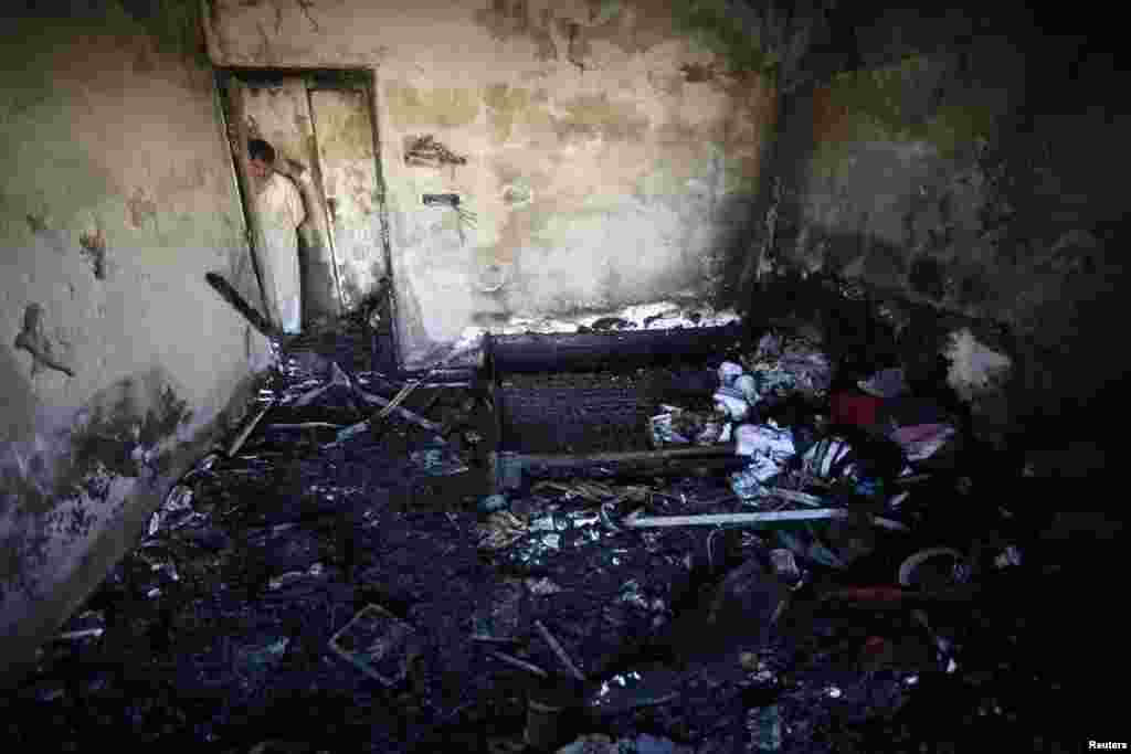 A man looks at his burned belongings in a room after a deadly bomb blast in a residential area in Karachi, Pakistan. (Reuters/Athar Hussain)