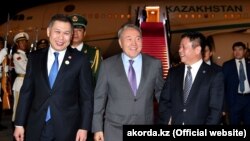 Президент Казахстана Нурсултан Назарбаев (в центре) по прибытию в Китай на фотоснимке, опубликованном 6 июня его пресс-службой. 