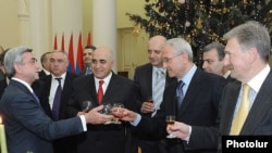 President Serzh Sarkisian, left, assures businessmen that the economy will improve in the new year, but some reports disagree with the president's optimism.