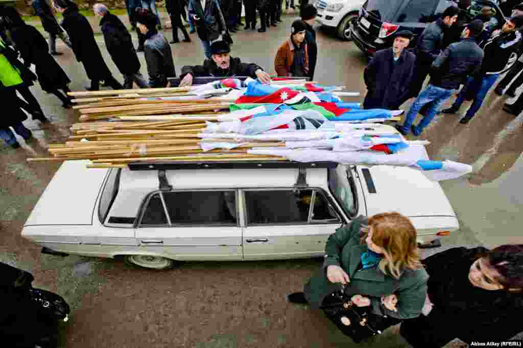 Азәрбайҗан оппозициясе әгъзалары 2018 елда Азәрбайҗан республикасына нигез салган Мамәд Әмин Расулзадәнең туган көне уңаеннар үткәрелгән чарада флагларын машинага җыя, 31 гыйнвар.