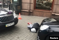 The suspected gunman lies on the ground at the scene of the shooting.