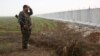 شبه‌نظامی ی‌پ‌گ پشت دیواری که سوریه را از ترکیه جدا می‌کند