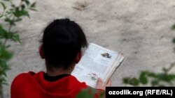 Uzbekistan - school girl is reading biology book at home, 15May2012 