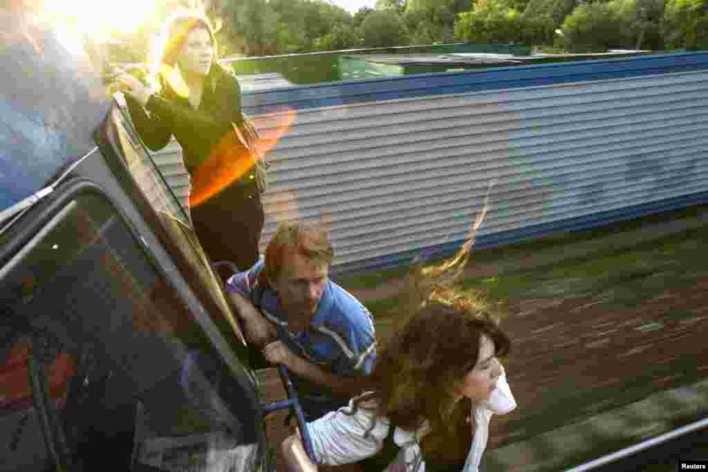 Activists Yekaterina Samutsevich (left), Oleg Vorotnikov (center), and Natalia Sokol travel on the outside of a commuter train near Moscow after refusing to buy tickets in June 2008. Samutsevich later became a member of Pussy Riot.