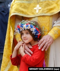 Дівчинка зі священиком УПЦ Київського патріархату під час відзначення Хрещення України-Руси. Київ, 28 липня 2017 року