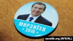 A campaign button for acting President Shavkat Mirziyaev