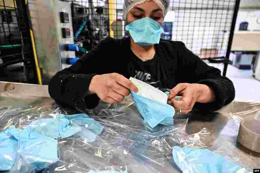 Сотрудница упаковывает респираторные маски на заводе&nbsp;Valmy в Мабли, Франция. Распространение коронавируса в Европе значительно увеличило объем работы этого завода, в прошлом месяце число сотрудников на производстве и на складе увеличили с 20 до 60 человек. 