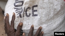 A newly arrived Somali refugee clutches a bag of relief maize outside a distribution centre in late July.