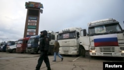 A police officer walks past a line of trucks whose drivers are taking part in a protest against a new fee at a parking lot in the Moscow region in December 2015.