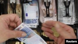 Euro banknotes and coins in open cash register at a shop in Olching, Germany.