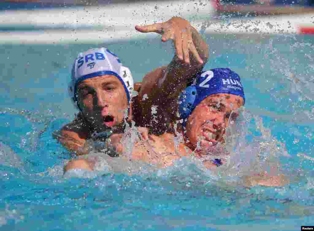 Gergo Zalanki of Hungary (right) and Nikola Jaksic of Serbia grapple with each other in an early round of the men&#39;s water polo competition.&nbsp;