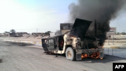 Smoke rises from an Iraqi Army vehicle following an attack by armed militants in the Anbar city of Fallujah on January 26.