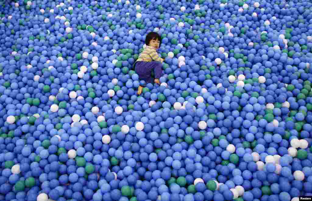 Two-year-old Nao Watanabe plays in a ball pit.
