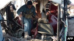 Afghan security forces inspect the site of a suicide attack on a bus carrying Afghan Army recruits in Jalalabad on April 11.