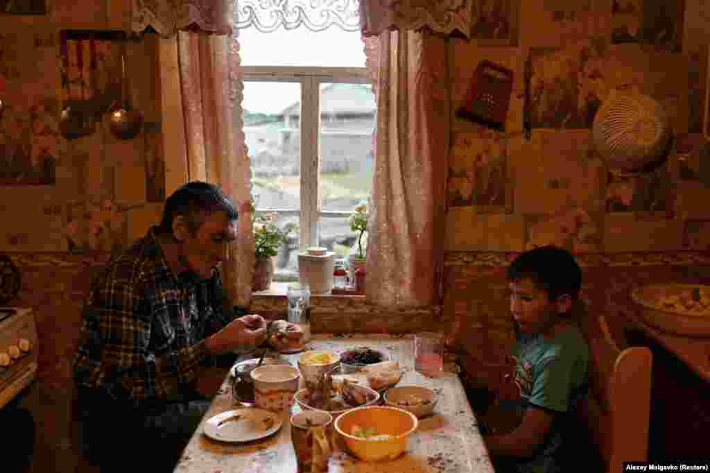 Ravil eats with his father, Dinar Izhmukhametov, 48. Ravil&#39;s parents are farmers but say they don&#39;t want their son to stay in the village when he grows up. &quot;Our eldest children live in the city and we&#39;re happy about that,&quot; said Dinar.