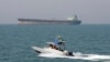 FILE-- In this July 2, 2012 file photo, an Iranian Revolutionary Guard speedboat moves in the Persian Gulf while an oil tanker is seen in background. 