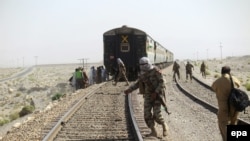 Pakistani soldiers stand at the scene of bomb blast that targeted the rail track near the town of Mach, southeast of Quetta, capital of the southwestern Balochistan Province.