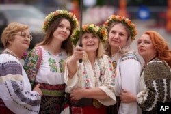 Women pose for a selfie during an event celebrating the country's folk clothing in Bucharest on May 12.