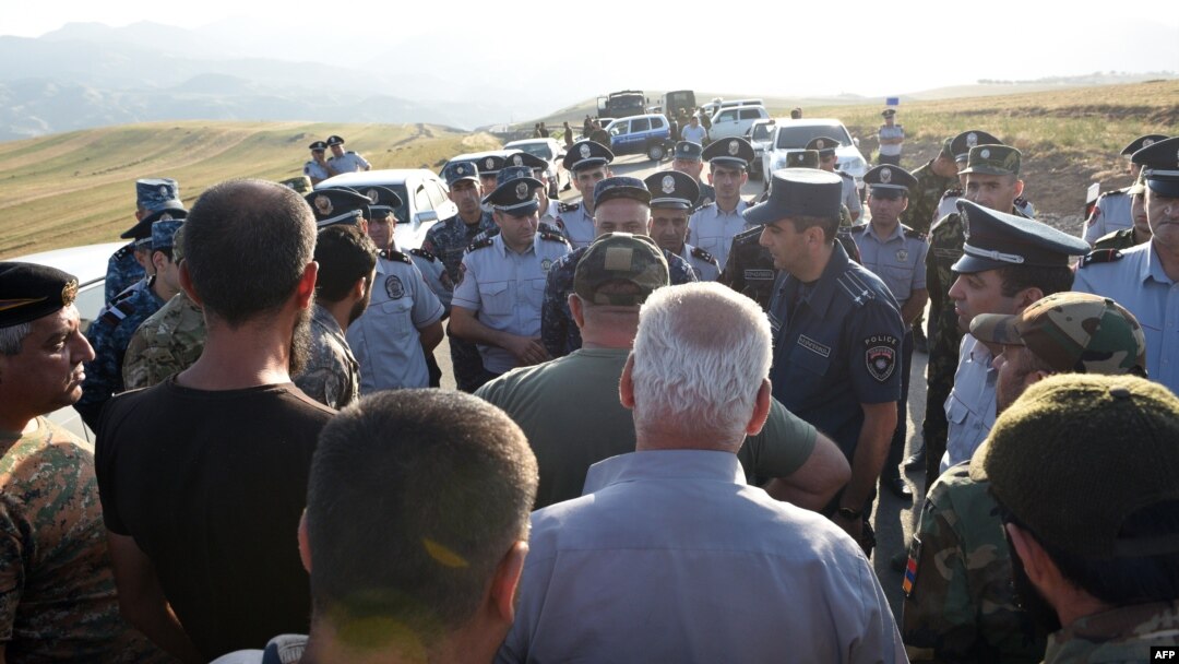 Armenian war veterans and army volunteers with the intention of unblocking the Lachin Corridor are confronted by law enforcement officers on a road just before the checkpoint.