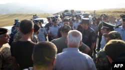 Armenian war veterans and army volunteers with the intention of unblocking the Lachin Corridor are confronted by law enforcement officers on a road just before the checkpoint.