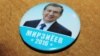 A campaign button for acting President Shavkat Mirziyaev